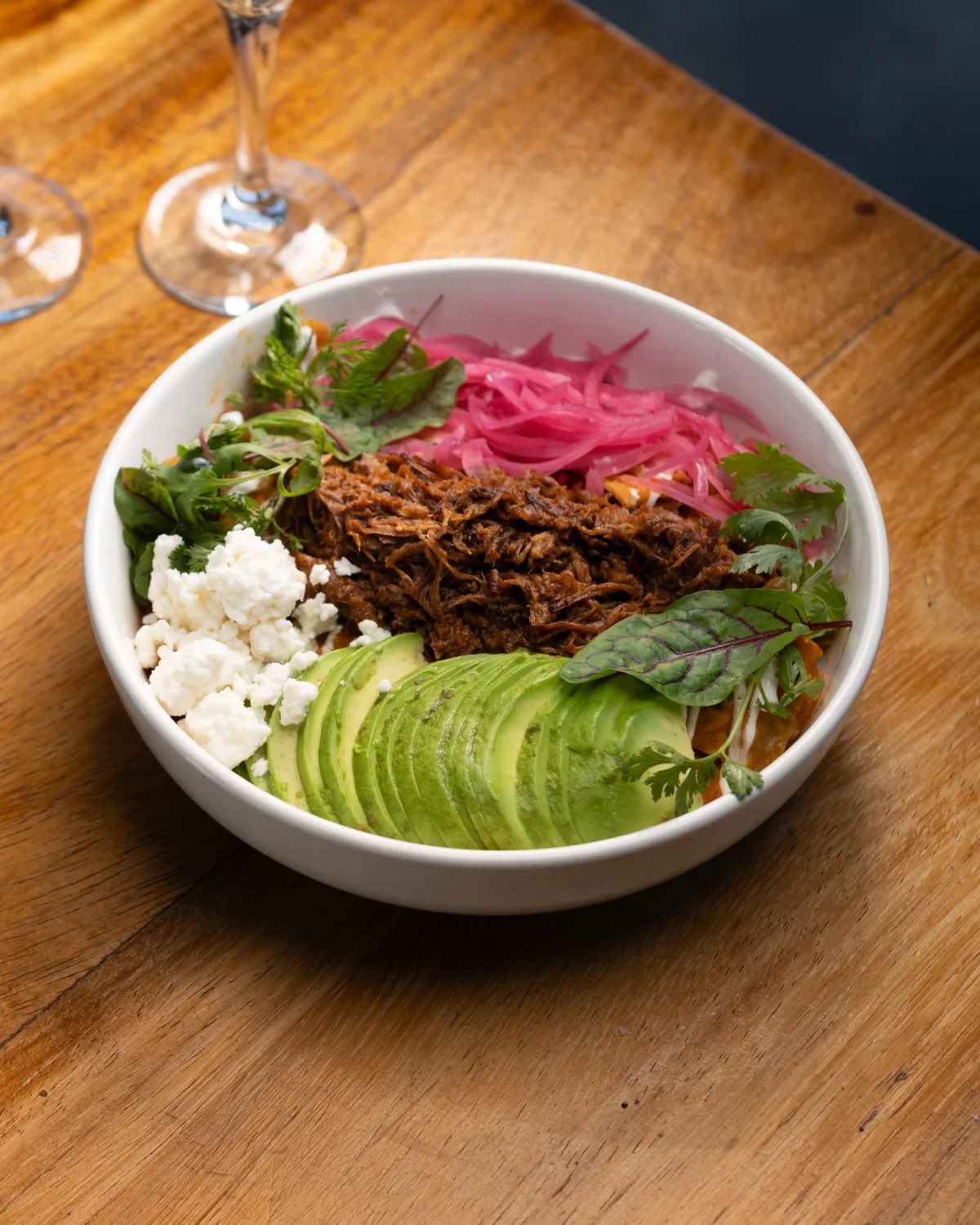 Lamb chilaquiles with avocado, fresh cheese and red onion
