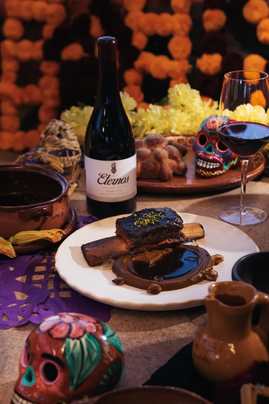 Braised beef short rib next to a bottle of Eternos wine