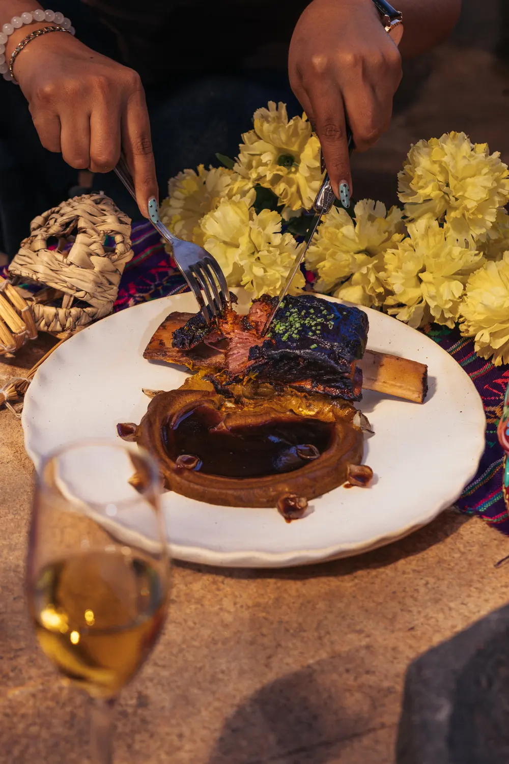 Guest cutting the braised short rib among marigolds